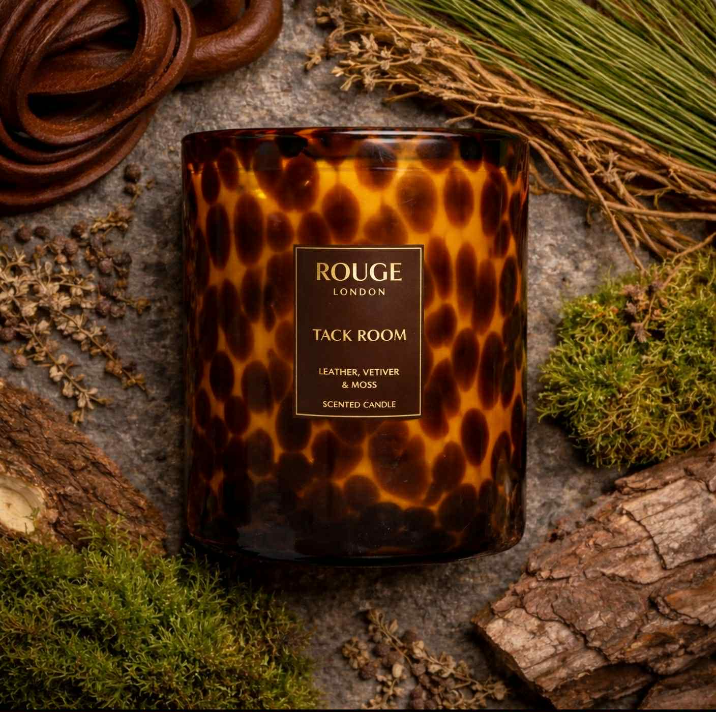 Tack Room 3 wick Candle with a tortoiseshell pattern. Leather, Vetiver & Moss on a rustic background.